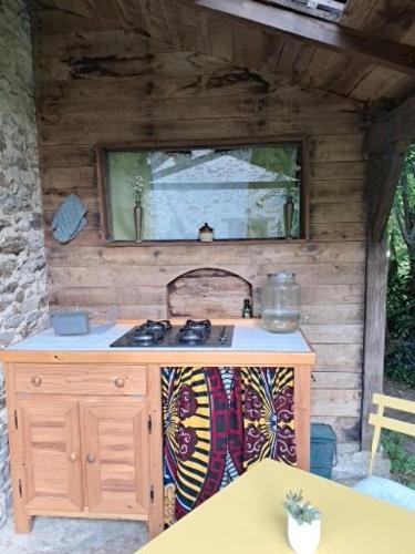 an outdoor kitchen with a sink and a stove at Chambre insolite in Saint-Mathieu