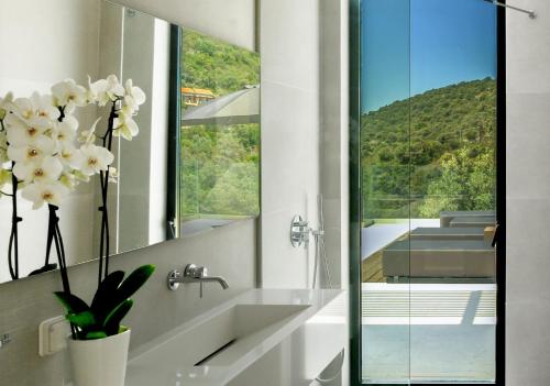 a bathroom with a sink and a mirror at Scirocco Luxury Villas & Suites in Vasiliki