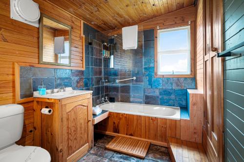 une salle de bain avec une baignoire, un lavabo et des toilettes dans l'établissement Mavista Cottage, à Adventure Bay