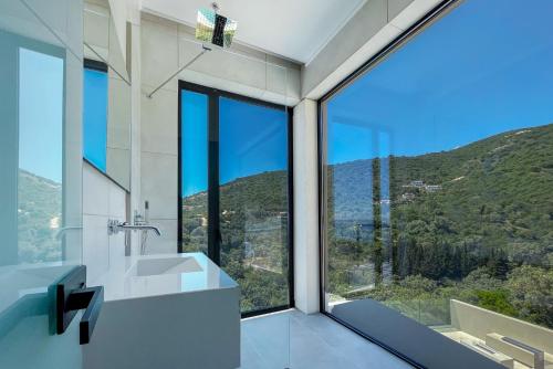 a bathroom with a sink and a large window at Scirocco Luxury Villas & Suites in Vasiliki