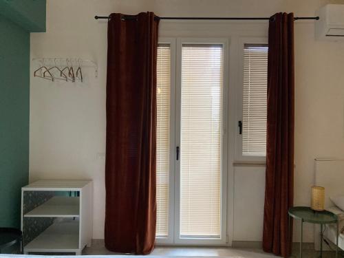 a room with two windows with curtains and a door at Nest - Family House in Santa Flavia