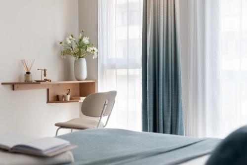 a bedroom with a bed and a chair and a window at Résidence Pierre & Vacances Premium Haguna in Biarritz