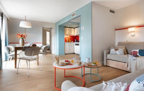 a living room with a couch and a table at Résidence Pierre & Vacances Premium Haguna in Biarritz