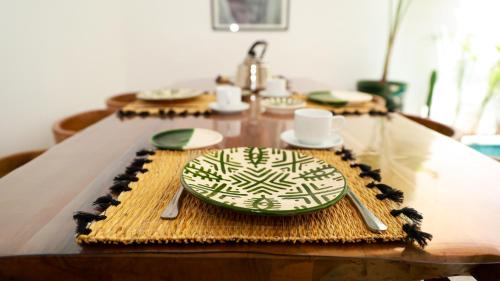 a table with a green plate and utensils on it at Riad Reflet D'orient Marrakech in Marrakech