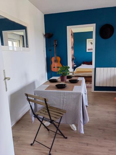 une chambre bleue avec une table et une chaise dans l'établissement T2 Seignosse Plage - 45M2, à Seignosse