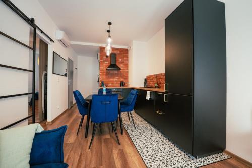 a kitchen and dining room with a table and blue chairs at AboutArtApartments - By the river in Wrocław