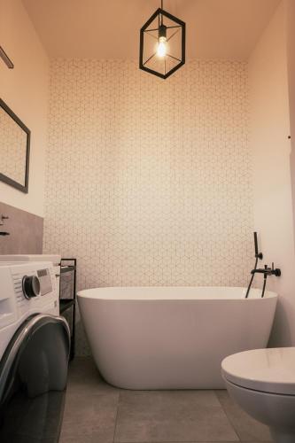 a bathroom with a white tub and a toilet at AboutArtApartments - By the river in Wrocław