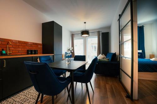 a kitchen and dining room with a table and chairs at AboutArtApartments - By the river in Wrocław