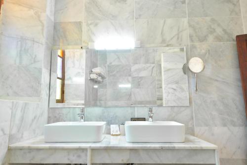 a bathroom with two sinks and a mirror at Riad Dilar Fes & Spa in Fès