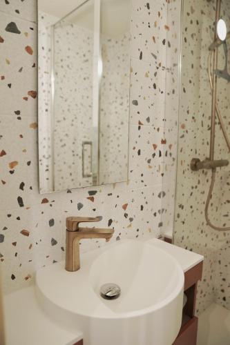 une salle de bain avec un lavabo et un miroir dans l'établissement Studio cocooning style naturel, aux Rousses