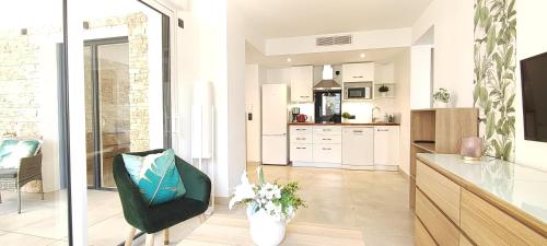 une cuisine avec une chaise verte dans une pièce dans l'établissement Appartement neuf à 100 m de la plage - New 100m from beach, à Fréjus