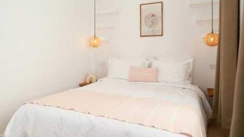 a bedroom with a white bed with a pink pillow at Riad Reflet D'orient Marrakech in Marrakech