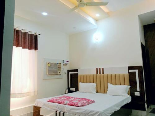 范兰德凡Hotel Dev Shri Residency ! near Prem mandir & ISCKON ! Fully AC rooms ! Café & Banquet, Free parking & Lift availability的带床和天花板的卧室