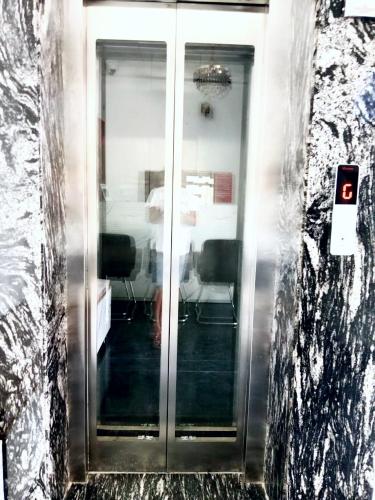 a hallway with glass doors in a building at Hotel Dev Shri Residency ! near Prem mandir & ISCKON ! Fully AC rooms ! Café & Banquet, Free parking & Lift availability in Vrindāvan