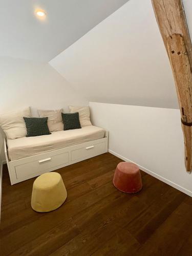 a room with a bed with two colorful ottomans at La Maisonnette in Templeuve
