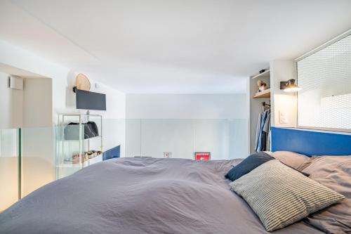 une chambre avec un lit avec une tête de lit bleue dans l'établissement Loft hyper-centre de Nice, à Nice