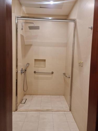 a shower stall in a bathroom with a tile floor at Sarwat Park Hotel Riyadh - Diplomatic Quarter in Riyadh