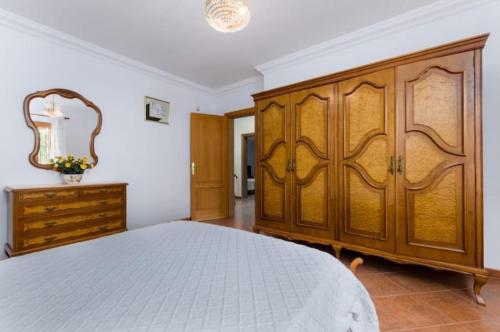 a bedroom with a large wooden cabinet and a bed at NEW! Villa Cas Padrins By BeBreeze for 7 with Pool and Mountain Views - Els Niguls in Lloseta