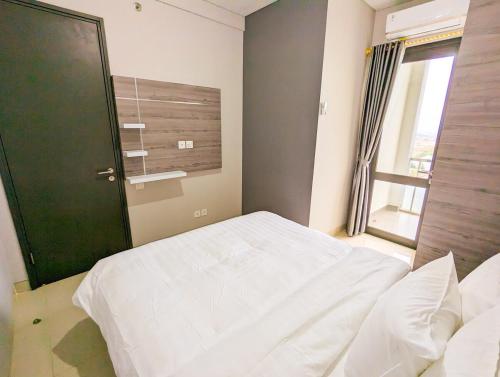 a bedroom with a white bed and a window at Lovina 31-ABAC at One Residence near Ferry Terminal in Pulau Sembakau Kecil
