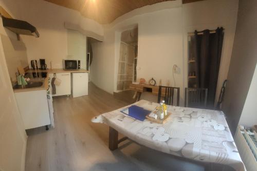 un salon avec une table et une cuisine dans l'établissement Appartement duplex avec balcons, à Quingey