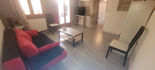 un salon avec un canapé et une table dans l'établissement Appartement duplex avec balcons, à Quingey