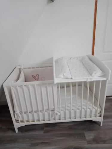 un berceau blanc avec une boîte dans une pièce dans l'établissement Maison conviviale à Épreville-en-Lieuvin avec jardin, à Épreville-en-Lieuvin