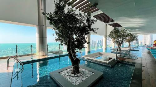 a house with a pool with a tree in it at Famous Infinity Pool 64th floor near Burj Khalifa in Dubai