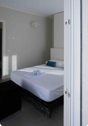 a bedroom with a white bed with a mirror at Antica Osteria sant Andrea in Misinto