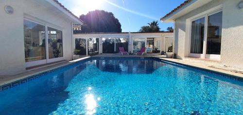 une piscine avec de l'eau bleue dans une maison dans l'établissement La Villa Azul, à Saint-Laurent-de-la-Salanque