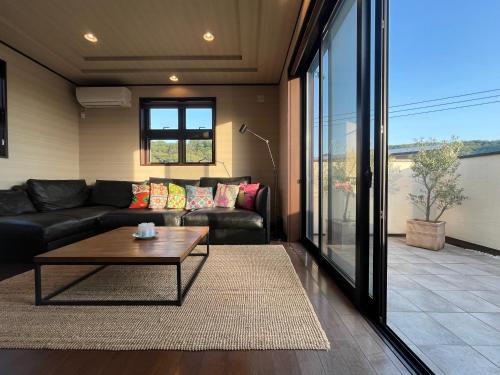a living room with a couch and a coffee table at Cielito Hayama 最大10名 海まで10分 テラスBBQ 葉山の空と海と富士山に出会うヴィラ in Hayama