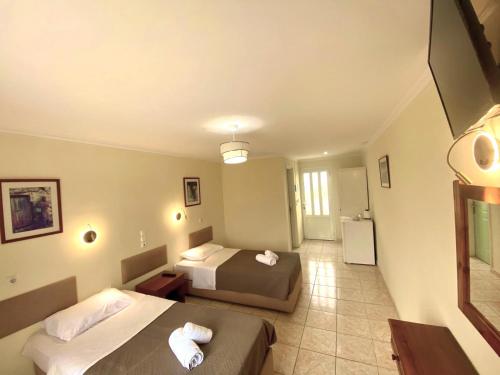 a hotel room with two beds and a bathroom at Laganas Holidays Hotel in Laganas