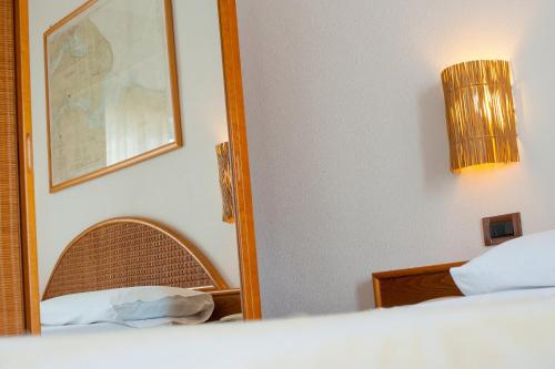 a bedroom with a mirror next to a bed at Ecoresort Le Sirene - Caroli Hotels in Gallipoli