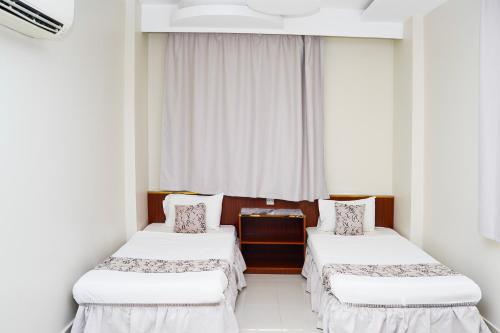 two beds in a room with a window at Al Bayrahaa Checkmyguest Muscat International Airport in Ghursheba