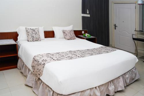 a large white bed in a hotel room at Al Bayrahaa Checkmyguest Muscat International Airport in Ghursheba