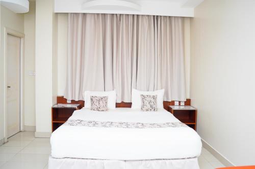 a bedroom with a large bed with white sheets and pillows at Al Bayrahaa Checkmyguest Muscat International Airport in Ghursheba