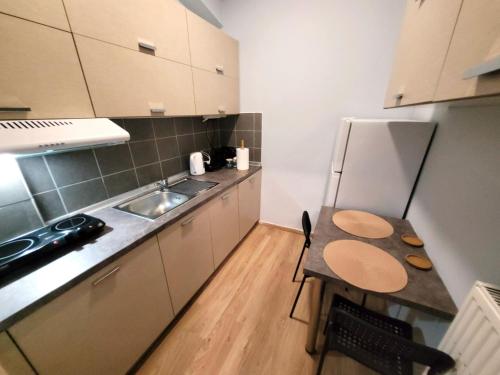 a small kitchen with a table and a sink at Metropole Vibe by GOLDENLAND in Thessaloniki