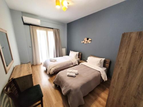 a bedroom with two beds and a window at Metropole Vibe by GOLDENLAND in Thessaloniki