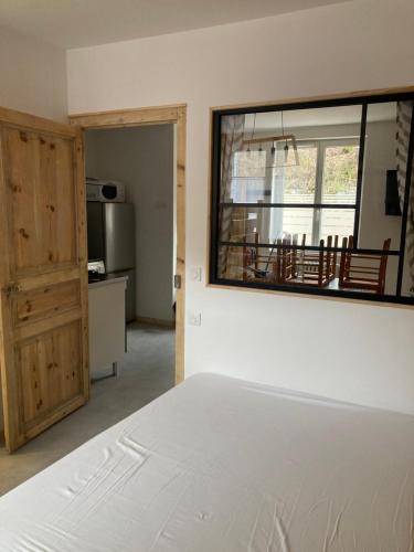 une chambre avec un lit et une grande fenêtre dans l'établissement Le Relais Charraud, à Le Mont-Dore