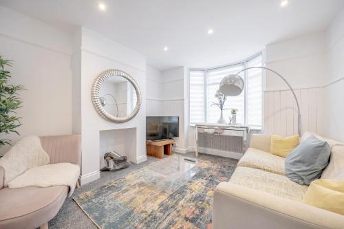 a living room with a couch and a mirror at New 3 Bed Victorian Dream House in Staines