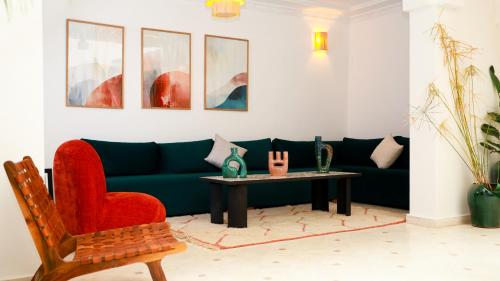 a living room with a green couch and a table at Riad Reflet D'orient Marrakech in Marrakech