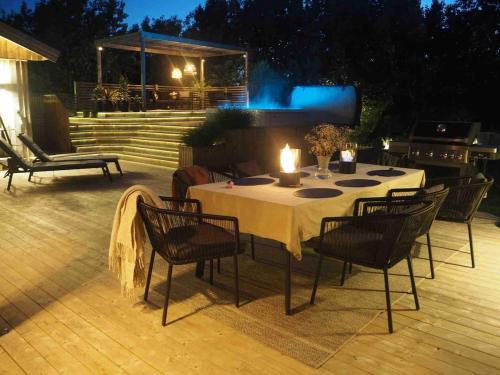 a table with chairs and candles on a patio at night at Social villa near the sea! in Torslanda