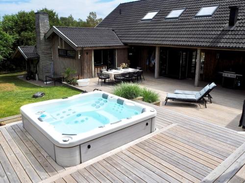 a hot tub sitting on a deck next to a house at Social villa near the sea! in Torslanda