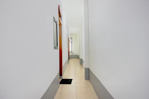 a hallway with white walls and a tile floor at Hotel O Medan near Universitas Sumatera Utara formerly Surya Residence in Sunggal