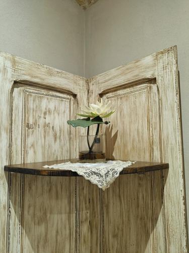 a flower in a vase on a table in a room at Le 2 Volte in Carmiano