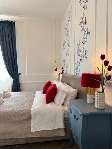 a bedroom with a bed with red pillows and a table at Umi B&B in Giulianova