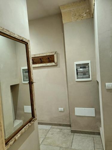 a bathroom with a mirror on the wall and a mirror at Le 2 Volte in Carmiano