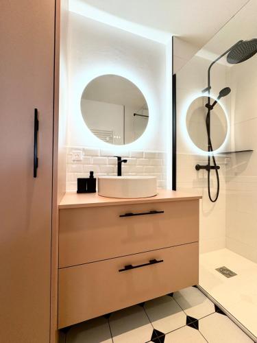 une salle de bain avec un lavabo et un miroir dans l'établissement Appartement rénové vue mer, Bénodet, à Bénodet