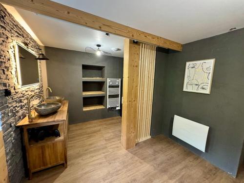 bagno con lavandino e parete in pietra di Appartement ambiance chalet avec vidéo-projecteur a Morez