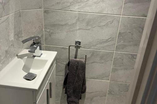 a bathroom with a sink and a toilet and a towel at Southgate Home - Sleeps 14 - Parking - Central in London
