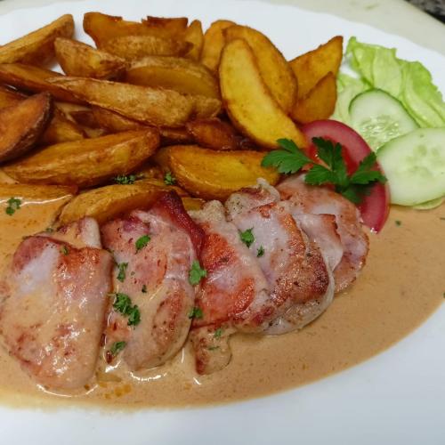 a plate of food with meat and french fries at Penzion Pod Boubínem in Kubova Huť